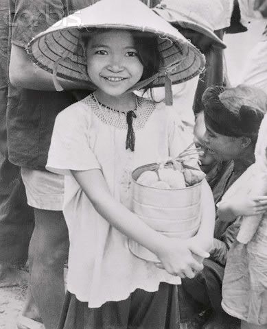 Even though she had to leave her home, this little Vietnamese refugee girls smiles happily knowing she is safe from the Communists after arriving in Saigon.